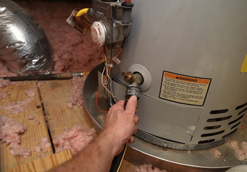 hand on hose connected to a hot water heater: Local Plumber & Plumbing Contractor Messick